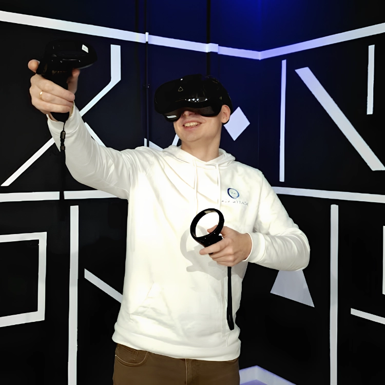 Ein Spieler mit einer VR Brille auf den Kopf und zwei Controllern in den Händen.